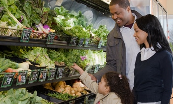 Mother daughter father selecting produce