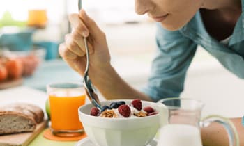 Woman eating yoghurt fruit