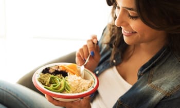 Young woman eating from bowl